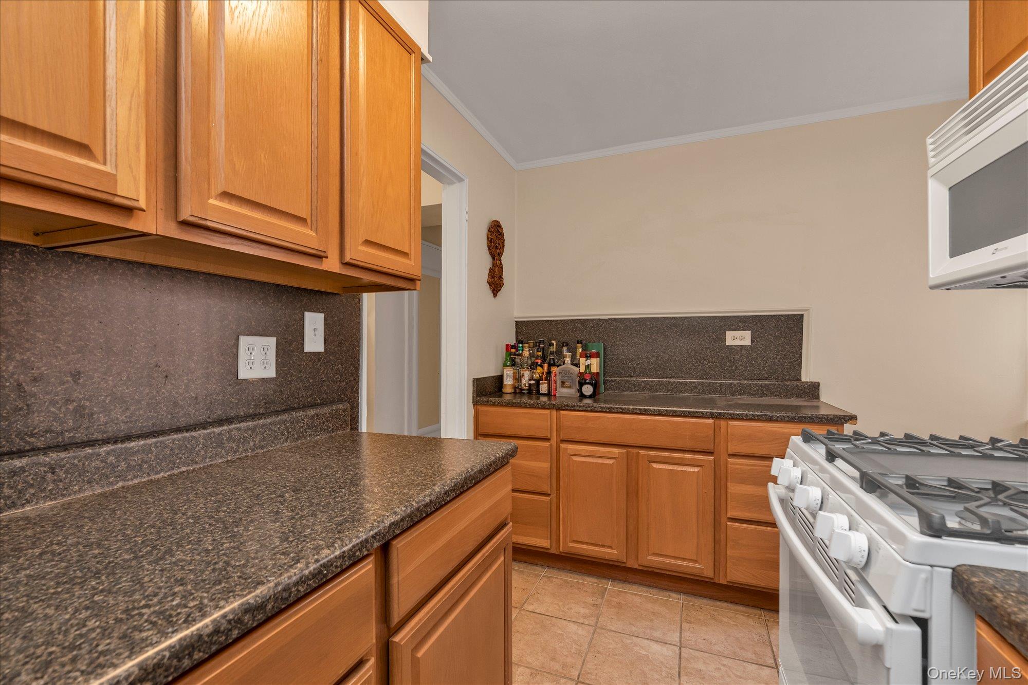 102-25 67th Road, Unit 4C Queens, NY 11375 - Photo 10 of 16 a kitchen with granite countertop cabinets stainless steel appliances and a counter space