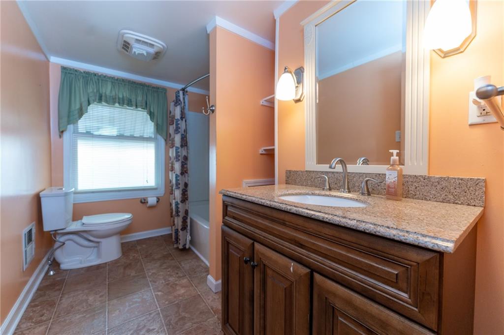 451 Ohio Avenue Rochester, PA 15074 - Photo 13 of 17 a bathroom with a granite countertop sink a toilet and a mirror