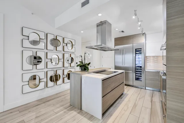 a kitchen with a stove a refrigerator and chairs
