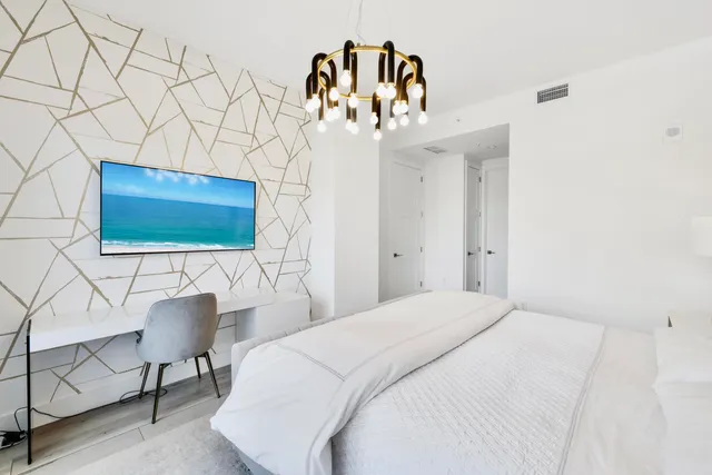 a bedroom with a bed and a chandelier