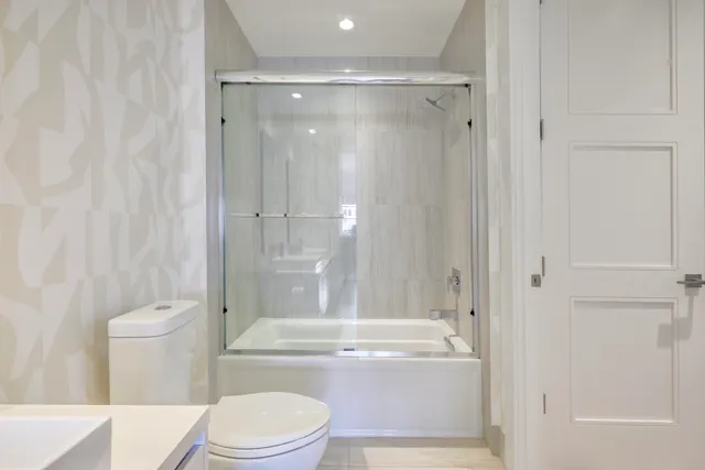 a bathroom with a granite countertop toilet a sink and bathtub
