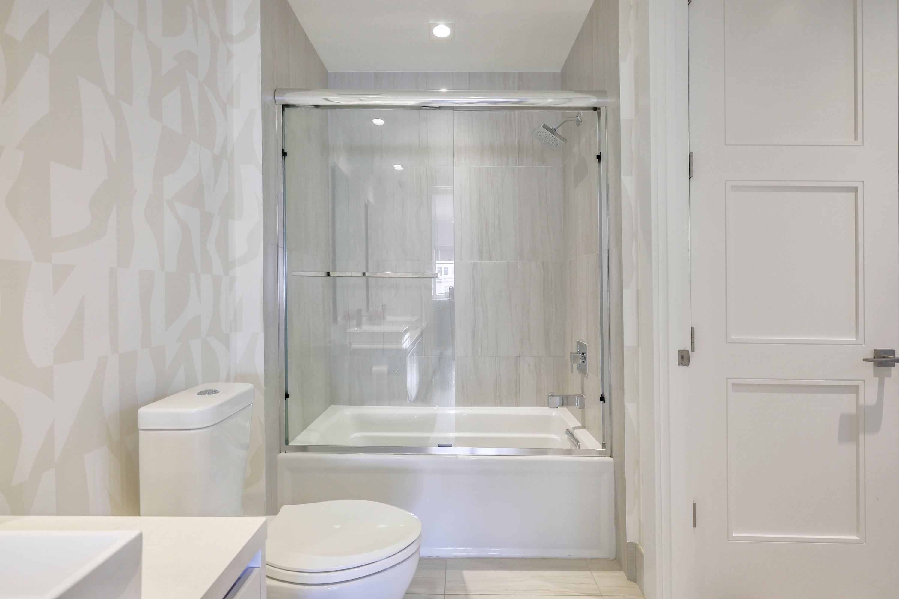 155 East Boca Raton Road, Unit 413 Boca Raton, FL 33432 - Photo 18 of 28 a bathroom with a granite countertop toilet a sink and bathtub