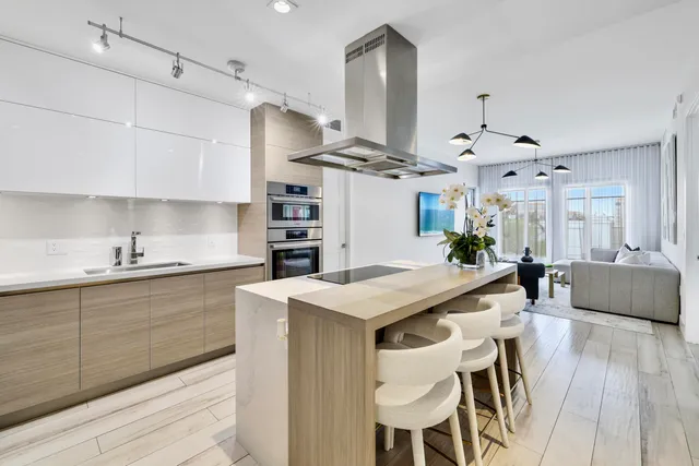 a kitchen with stainless steel appliances kitchen island a dining table chairs and sink