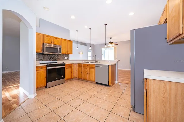 a kitchen with stainless steel appliances granite countertop a stove top oven sink and cabinets