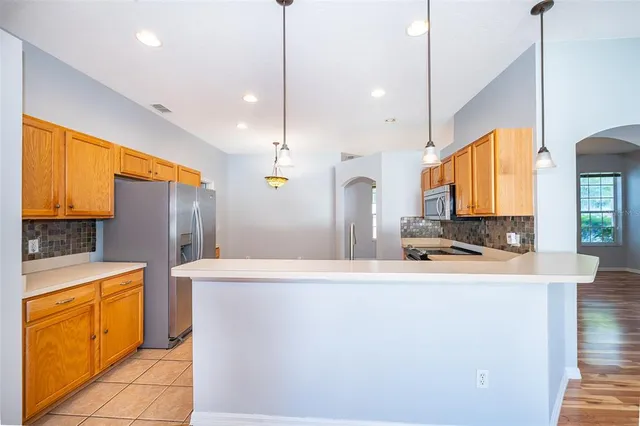 a kitchen with stainless steel appliances granite countertop a sink a stove and a refrigerator