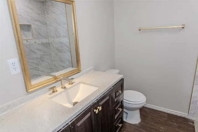 a bathroom with a granite countertop sink toilet and a shower