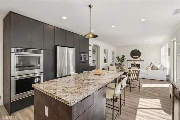 a kitchen with stainless steel appliances granite countertop a table chairs and a refrigerator