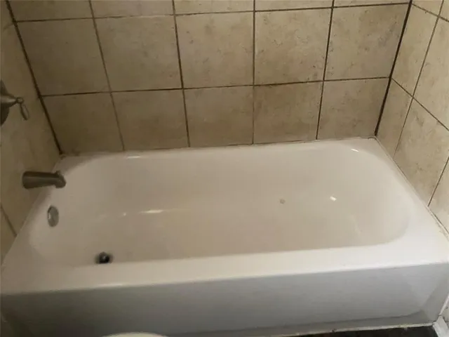 an empty room with a ceiling fan and window