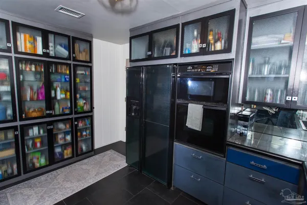 a kitchen with stainless steel appliances granite countertop a refrigerator and a wooden floor