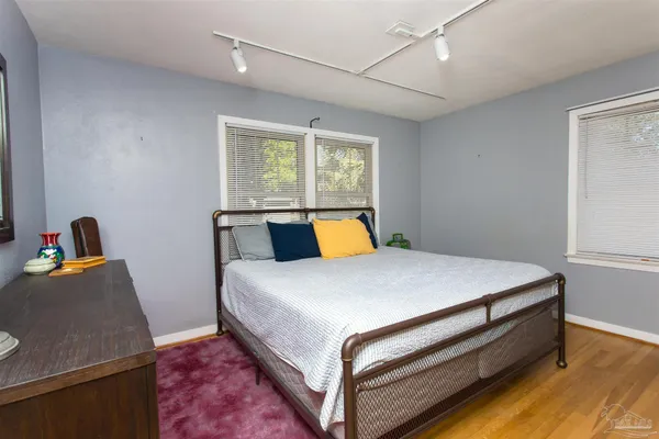 a bed sitting in a bedroom next to a window