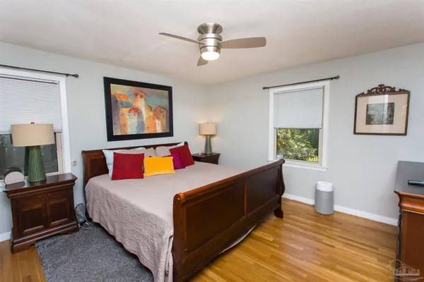 a bedroom with a bed and a lamp on the dresser