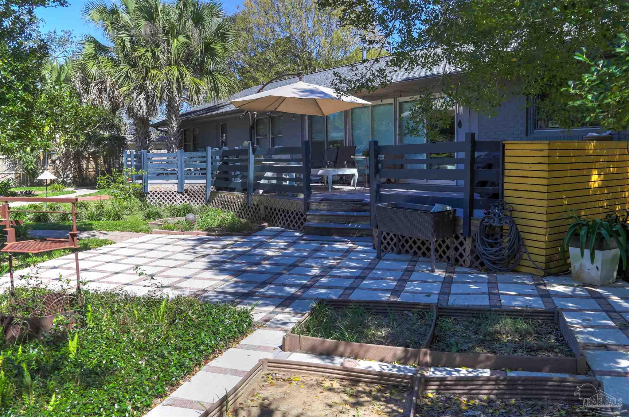 4415 Piedmont Road Pensacola, FL 32503 - Photo 35 of 43 a patio with a table and chairs under an umbrella