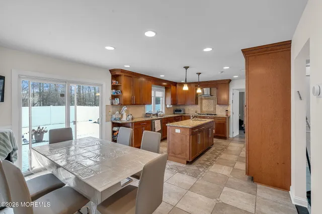 a large kitchen with a large counter top space a sink stainless steel appliances and cabinets