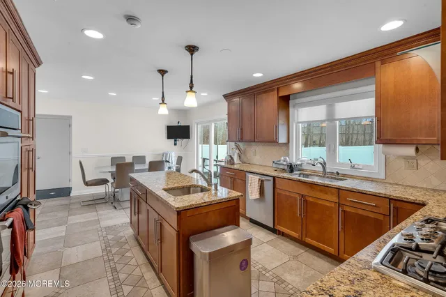 a kitchen with stainless steel appliances granite countertop a sink a stove and a refrigerator