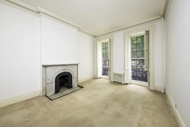 an empty room with fireplace and window
