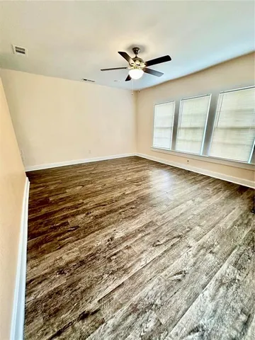 a view of a room with wooden floor and ceiling fan