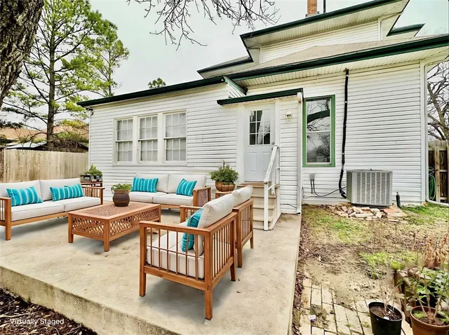 a view of a patio with couches table and chairs and potted plants