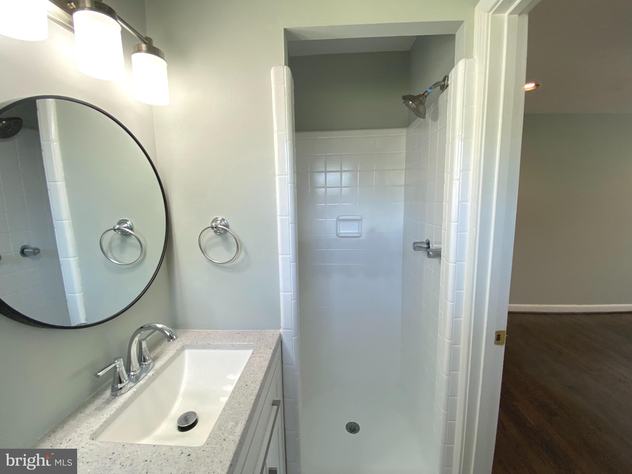 5072 Rock Springs Road Warrenton, VA 20187 - Photo 17 of 28 a bathroom with a sink a mirror a vanity and shower