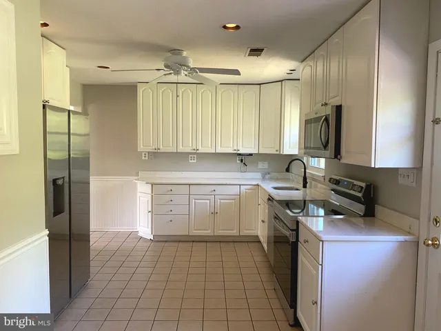 a kitchen with a sink a refrigerator and cabinets