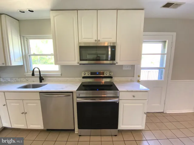 a kitchen with a stove sink and microwave