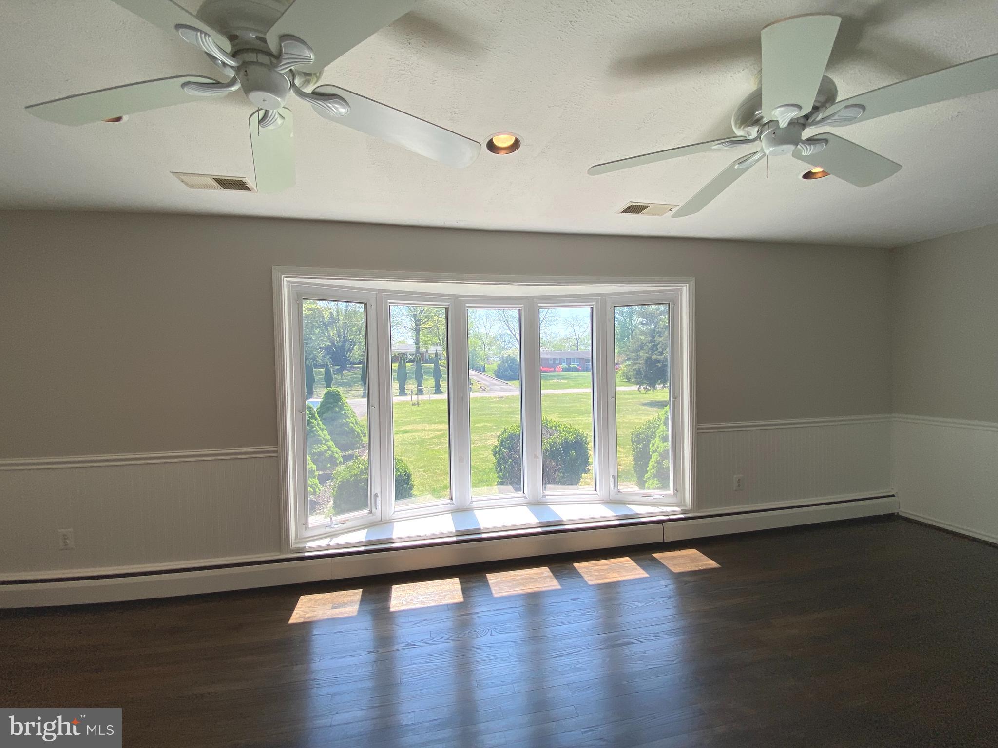 5072 Rock Springs Road Warrenton, VA 20187 - Photo 9 of 28 an empty room with wooden floor fan and windows