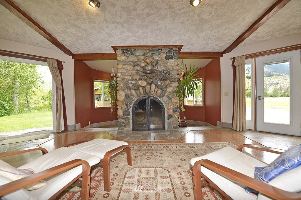 26 Beaver Pond Road Twisp, WA 98856 - Photo 7 of 31 a living room with fireplace furniture and a floor to ceiling window