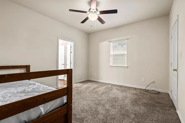 a view of a bedroom with a bed and wooden floor