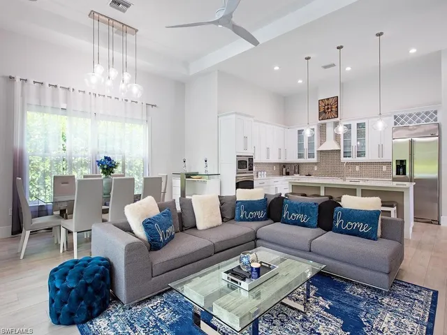 a living room with furniture kitchen view and a chandelier