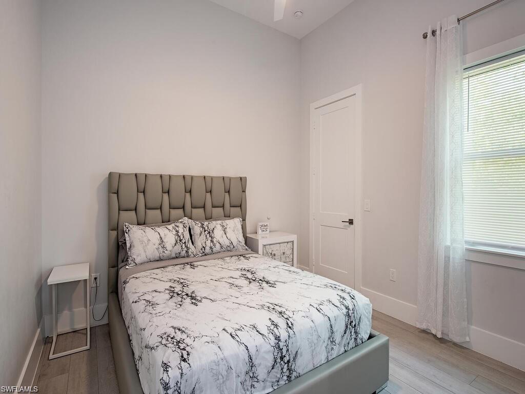 710 Soll Street Naples, FL 34109 - Photo 9 of 12 a bedroom with a bed and wooden floor