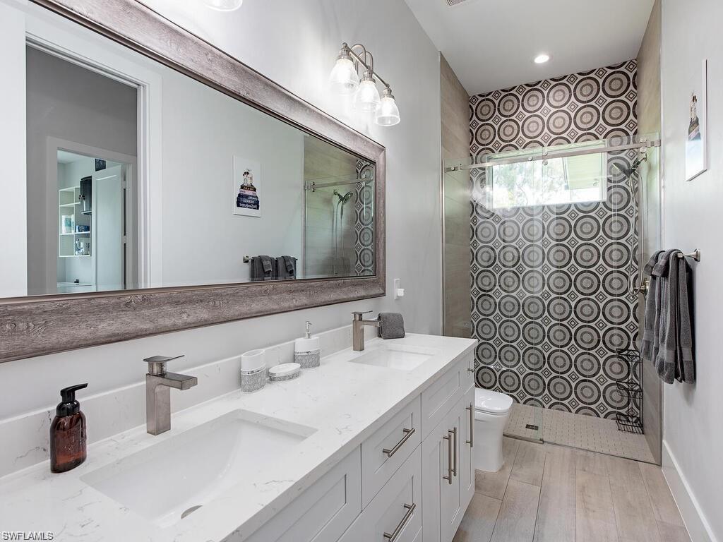 710 Soll Street Naples, FL 34109 - Photo 10 of 12 a bathroom with a double vanity sink toilet and shower