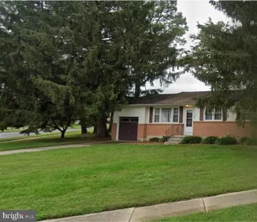 a view of a house with a big yard and large trees