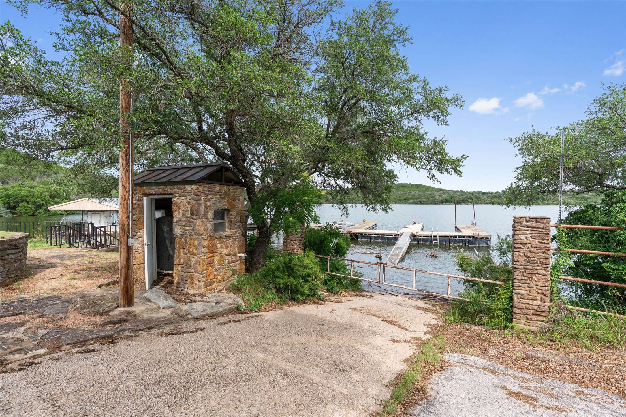 325 Eagle Rest Burnet, TX 78611 - Photo 24 of 40 A stone outbuilding and gated boat ramp lead to serene waterfront access and docks on the lake.