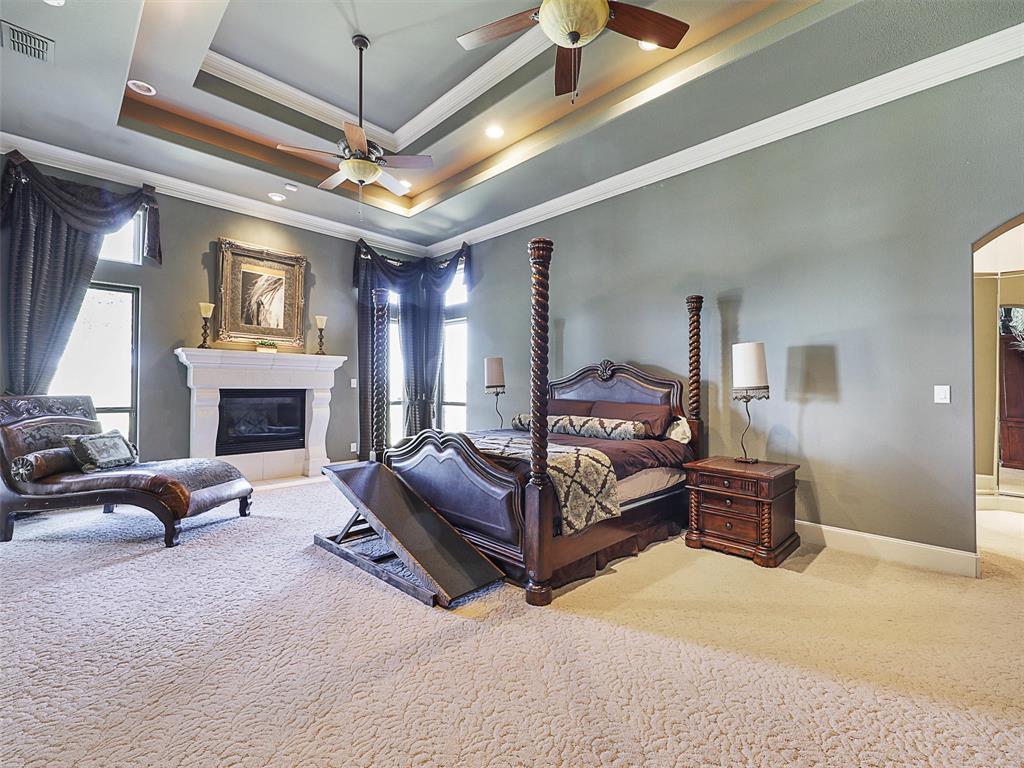 1200 McReynolds Road Sanger, TX 76266 - Photo 11 of 20 a spacious bedroom with a bed couch chandelier and a fireplace