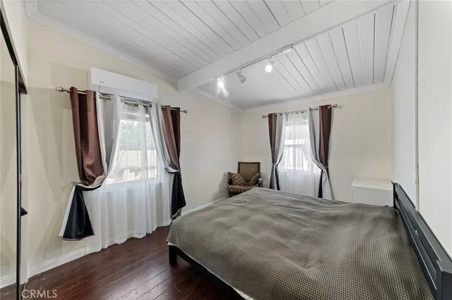 a bedroom with a bed and a wooden floor