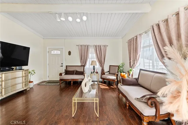 a living room with furniture flat screen tv and a large window