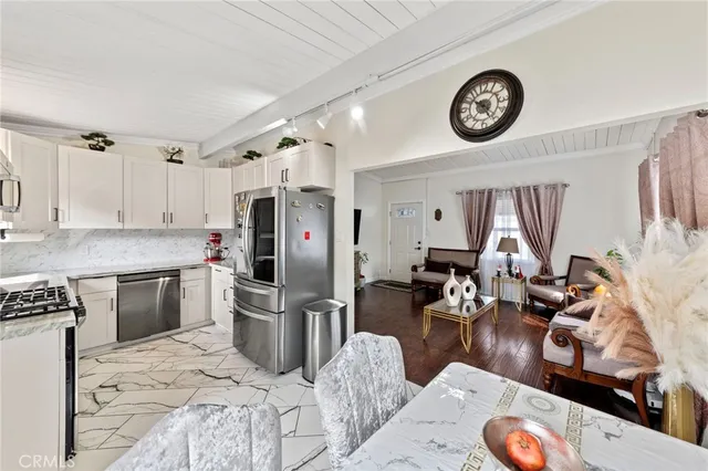 a kitchen with stainless steel appliances granite countertop a refrigerator sink and stove