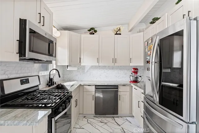 a kitchen with granite countertop a sink stove and refrigerator