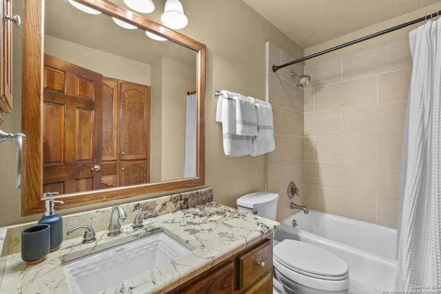 a bathroom with a granite countertop sink toilet and shower