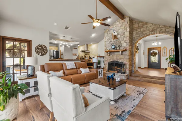 a living room with furniture a fireplace and a chandelier