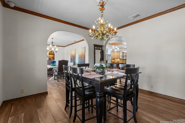 a view of a dining room with furniture a chandelier and wooden floor