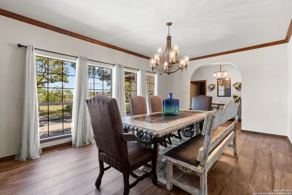 a dining room with furniture a chandelier and wooden floor