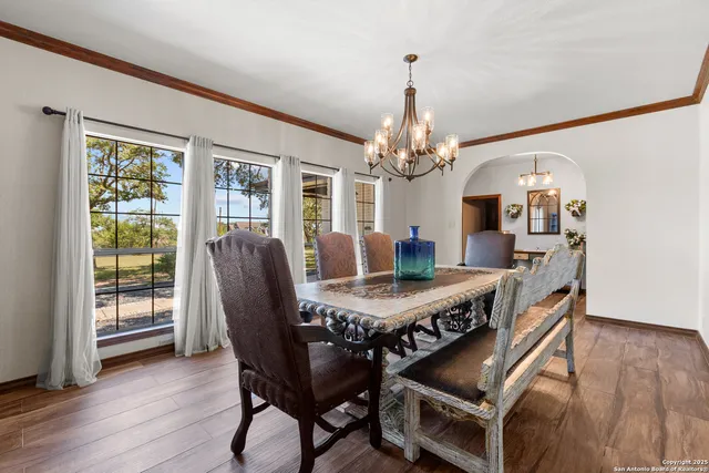 a dining room with furniture a chandelier and wooden floor