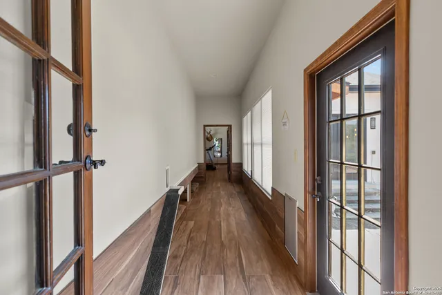 a view of a hallway with wooden floor and staircase