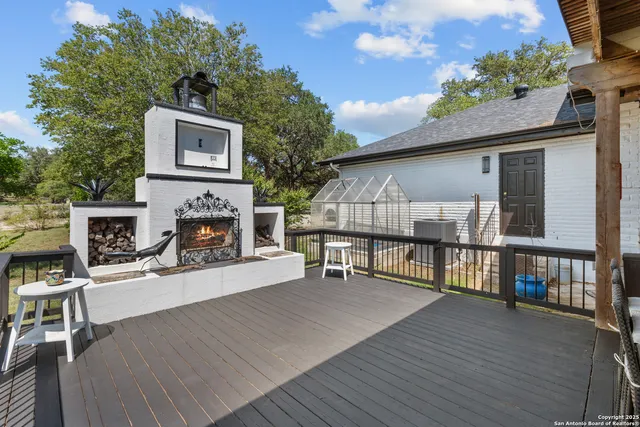 a view of a house with wooden deck and furniture