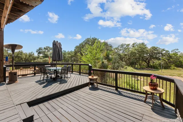 a view of a balcony with chairs and wooden fence