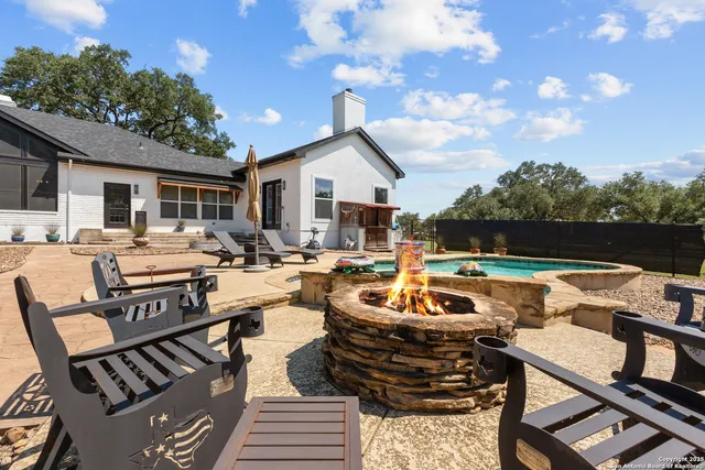 a view of a patio with couches table and chairs with wooden fence