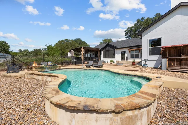 a view of a house with swimming pool and sitting area