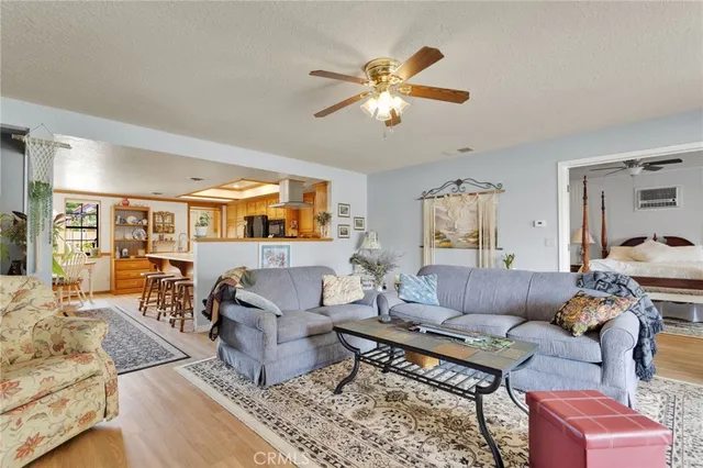 a living room with stainless steel appliances furniture cabinets and a large window