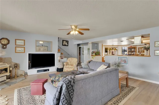 a living room with furniture a flat screen tv and a large window