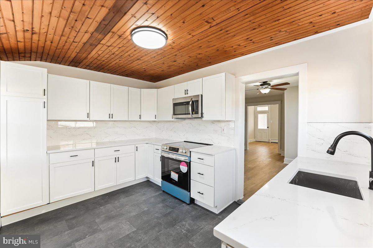 8 Convent Road Aston, PA 19014 - Photo 5 of 28 a kitchen with stainless steel appliances granite countertop a stove a sink and a refrigerator